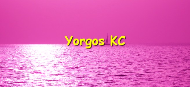 A photograph of the sea and the sky. A small sail-boat is seen at the horizon. The photograph is overlaid with a pink layer. There are yellow letters saying "Yorgos KC"